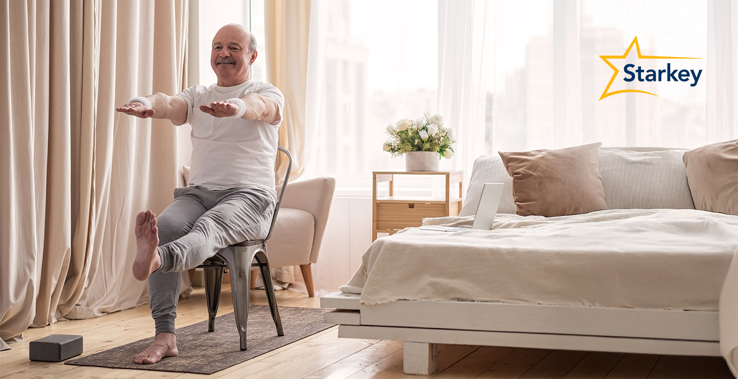 Image of senior man sitting on chair and doing a balance exercise